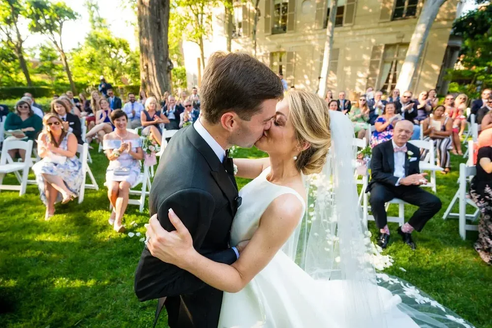 Bride and groom share their first kiss during the outdoor wedding ceremony at Meridian House in Washington DC