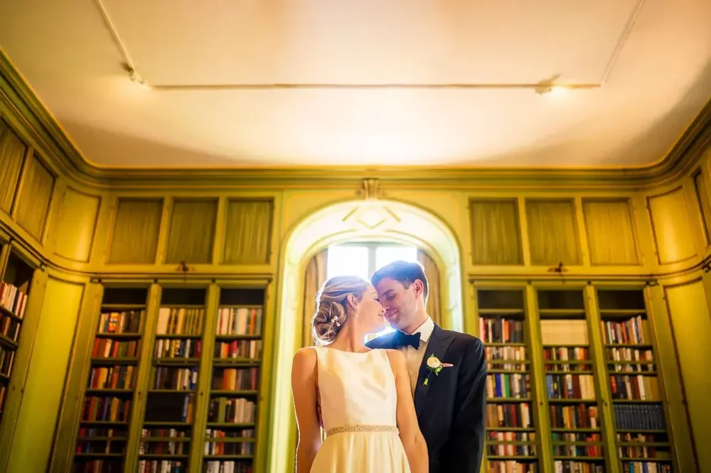 Couple embracing in the elegant green library inside Meridian House
