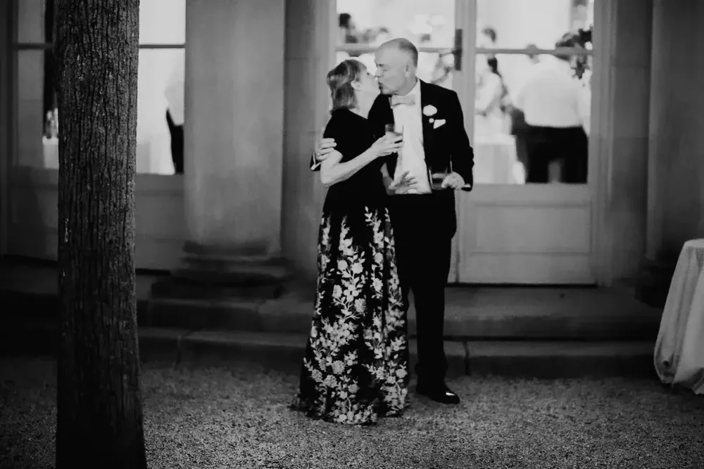 Romantic black and white portrait of a couple kissing outside Meridian House