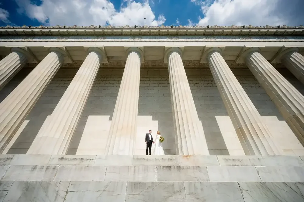 Couple between Lincoln Memorial columns on their Meridian House wedding day