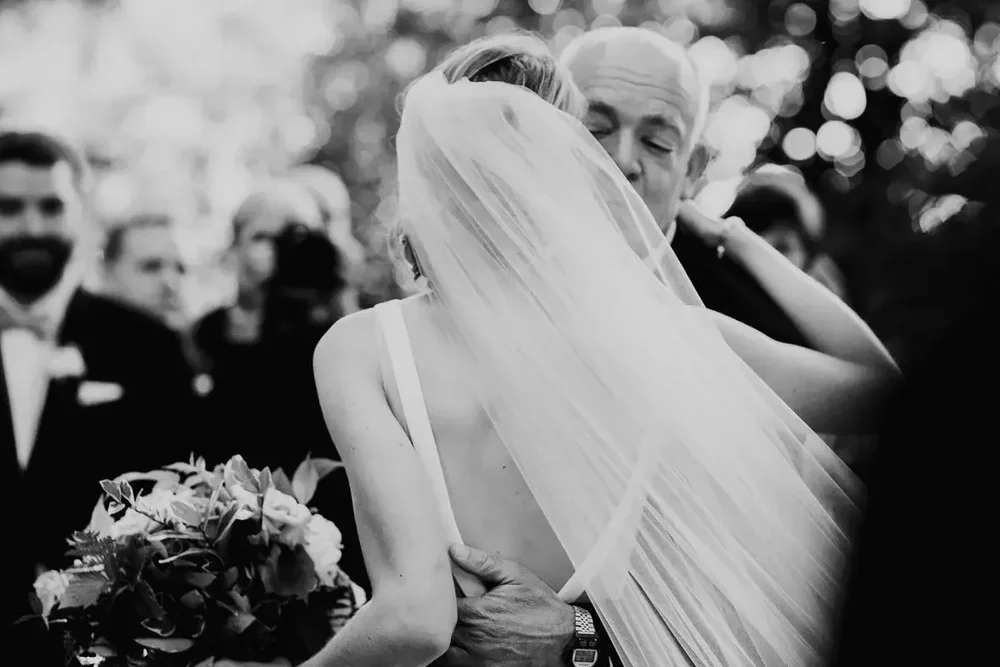 Emotional moment as father kisses the bride while giving her away at Meridian House