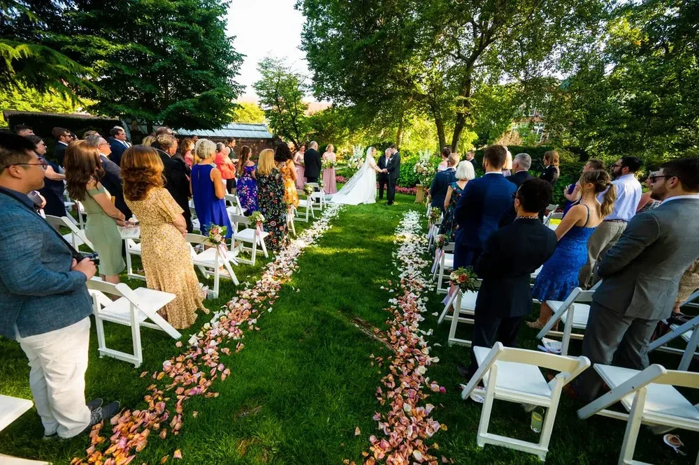 Guests watch the bride and groom exchange vows in the Meridian House garden