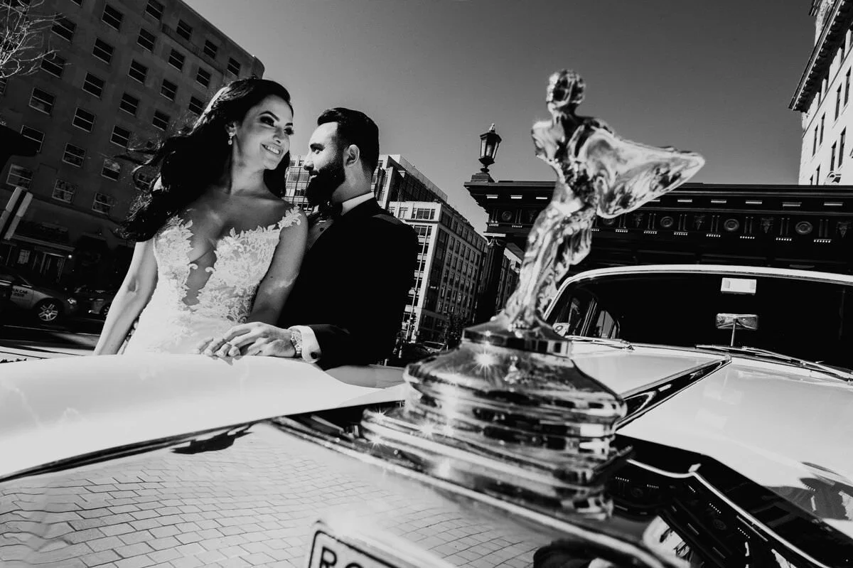Bride and groom photographed in Washington DC beside a classic luxury car by a wedding photographer