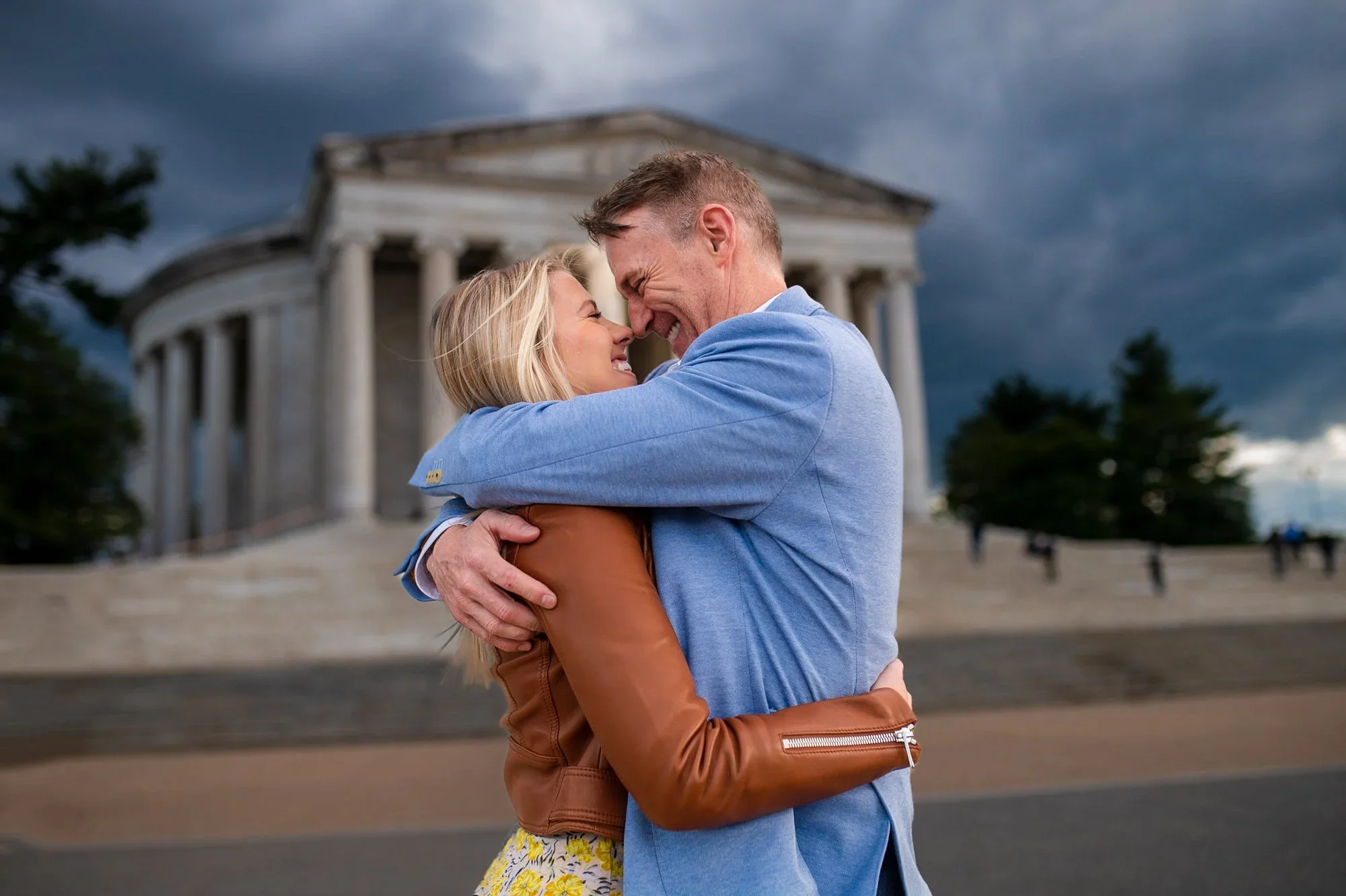 Engagement photos at the Thomas Jefferson Memorial in Washington DC showing a couple embracing in front of the monument