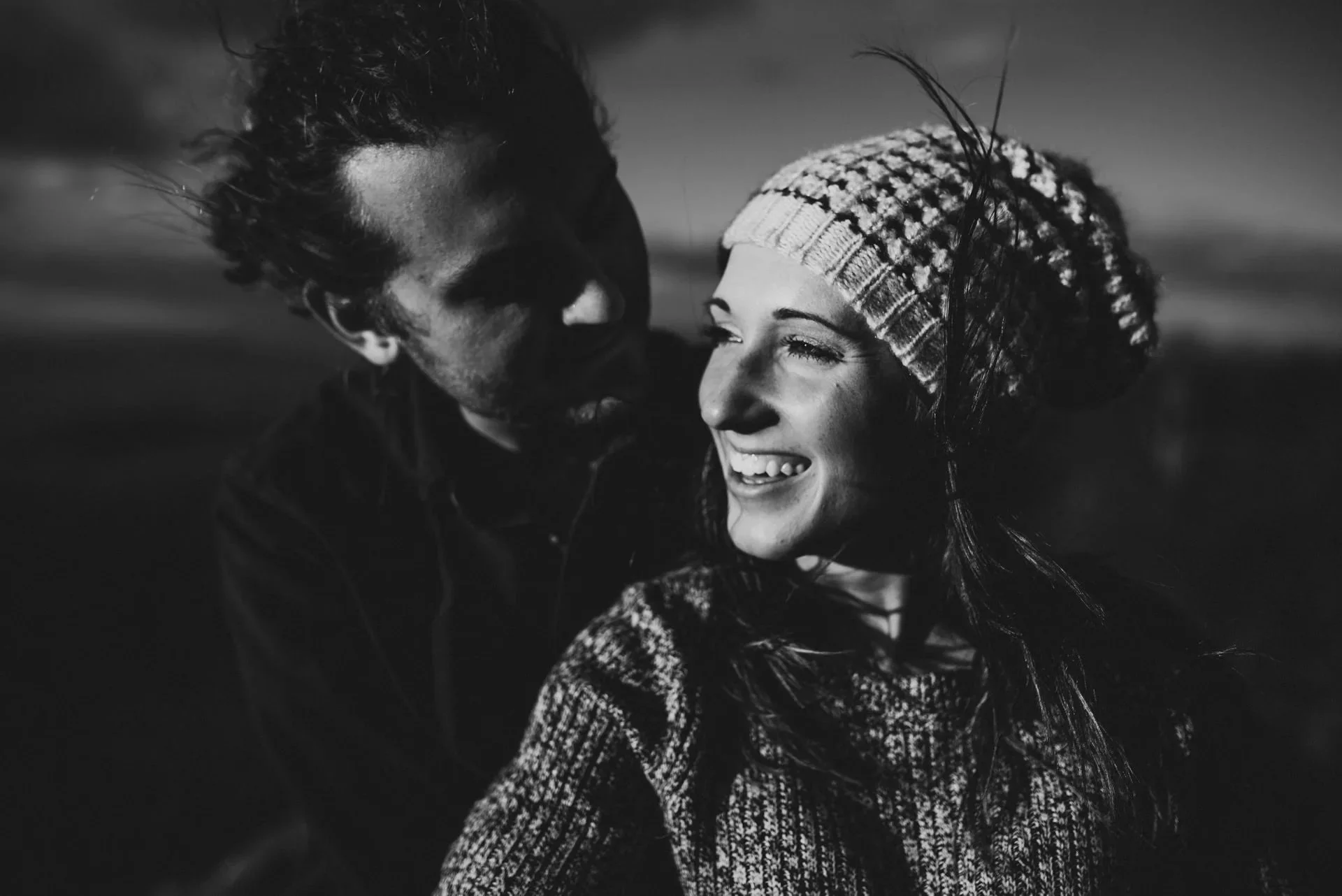 Black and white intimate engagement photo of a smiling couple in Shenandoah National Park with close-up candid moment and natural light.