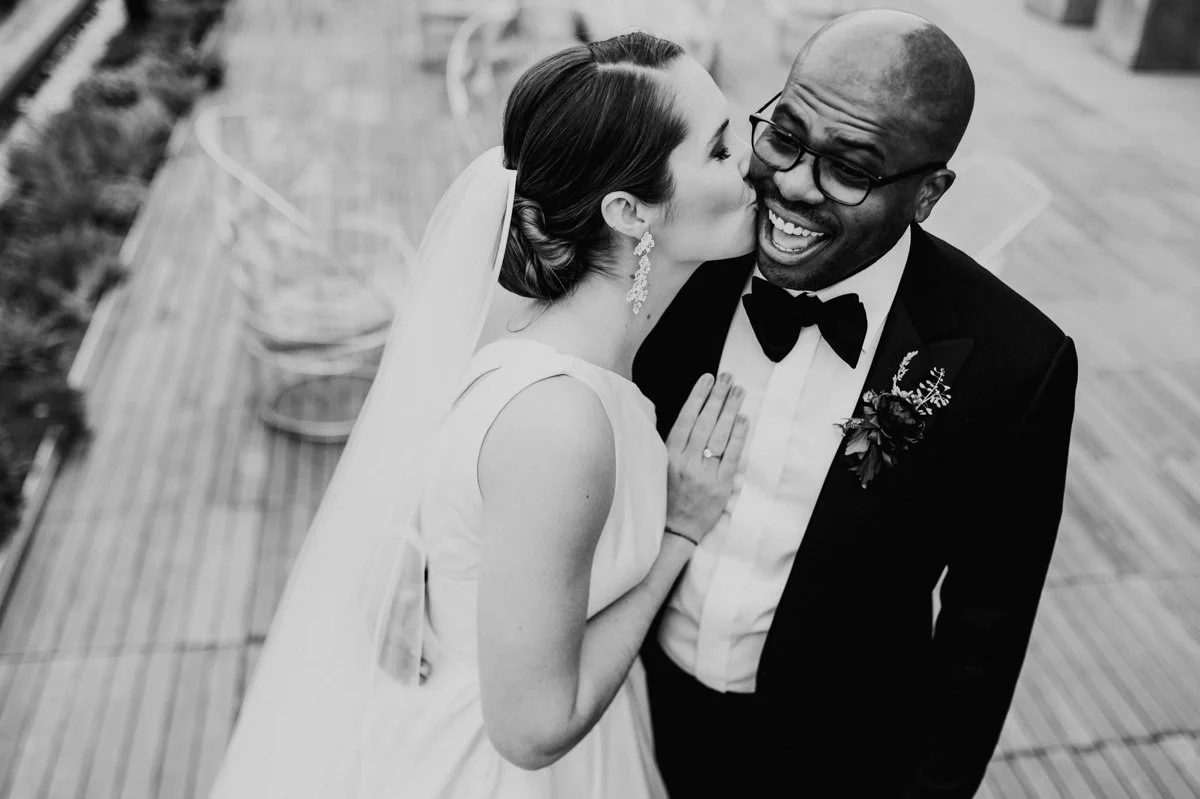Multicultural couple kissing on the rooftop at The LINE Hotel wedding in Washington DC