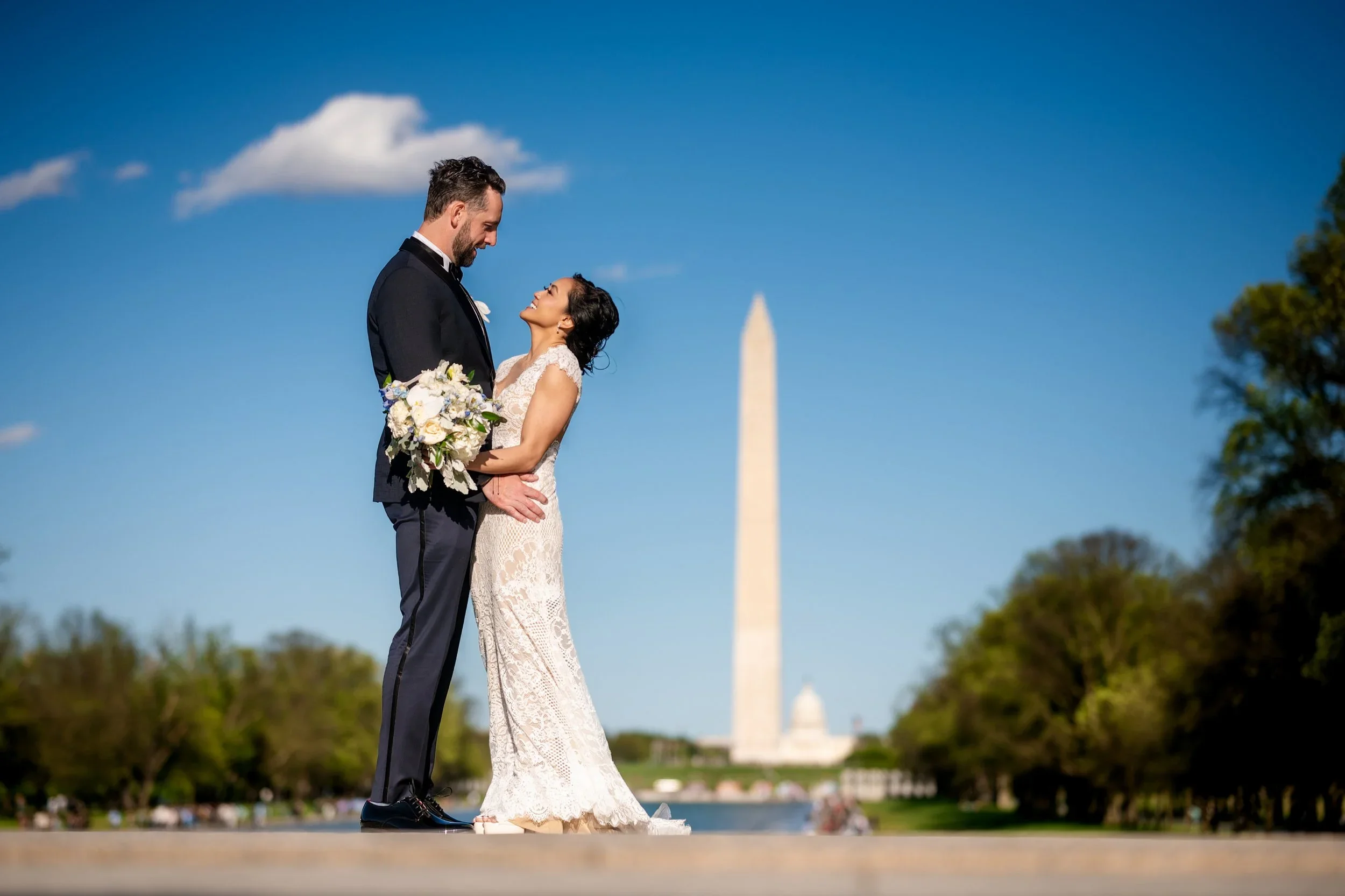 Bride and groom photographed in Washington DC with the Washington Monument during a destination wedding portrait session