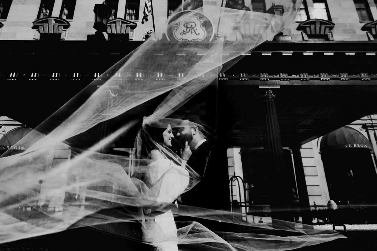 t. Regis Washington DC wedding portrait with a bride and groom kissing beneath a flowing veil outside the hotel.
