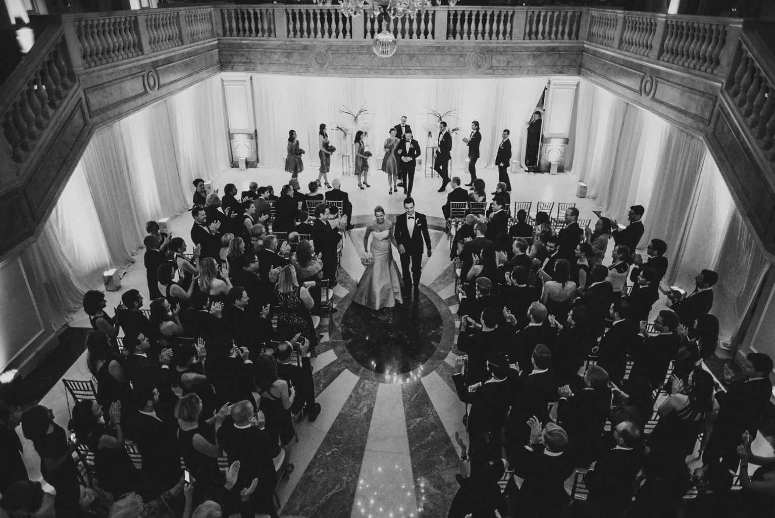Documentary wedding ceremony in Washington DC photographed from above as the couple walks down the aisle surrounded by guests