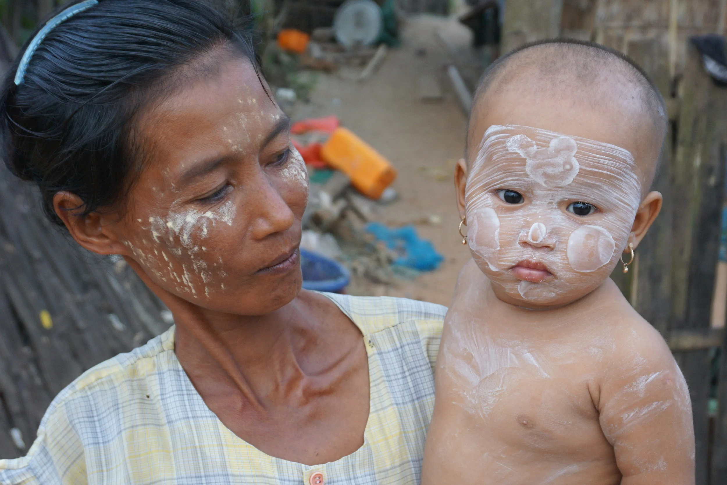 A baby and mother both wearing thanaka. 