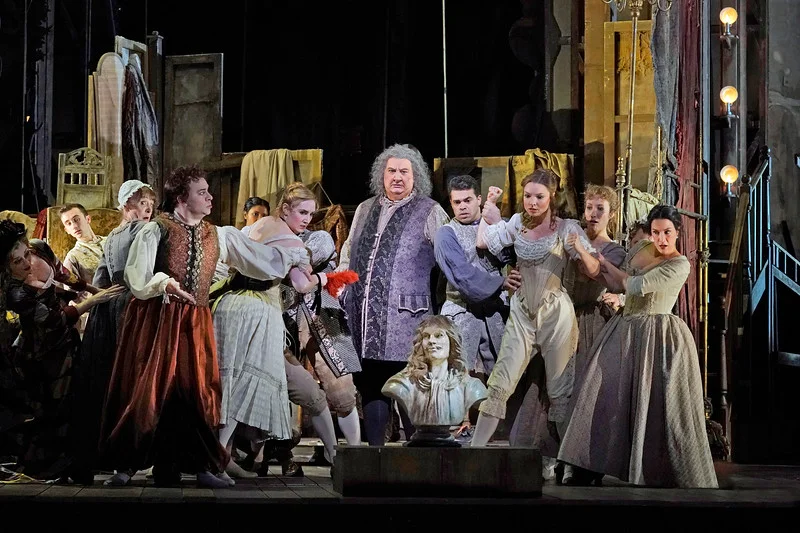 Backstage in Act I, Scene I: Ambrogio Maestri is Michonnet, surrounded by his troupe