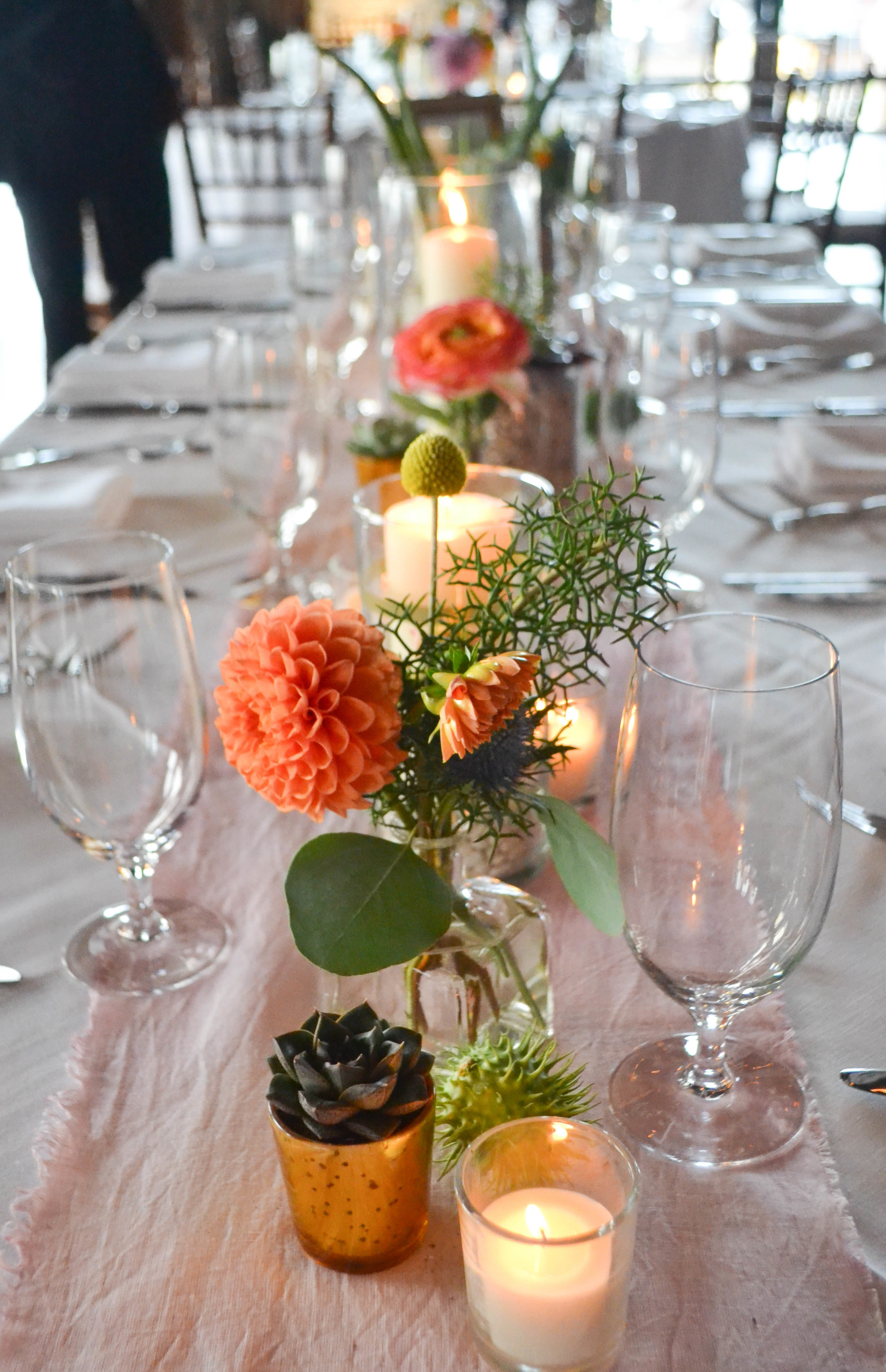 Liberty Warehouse Southwest Succulent Mexican wedding. Rosehip Floral BrooklynOrange, pink, white and slate blue centerpieces with succulents and candles.