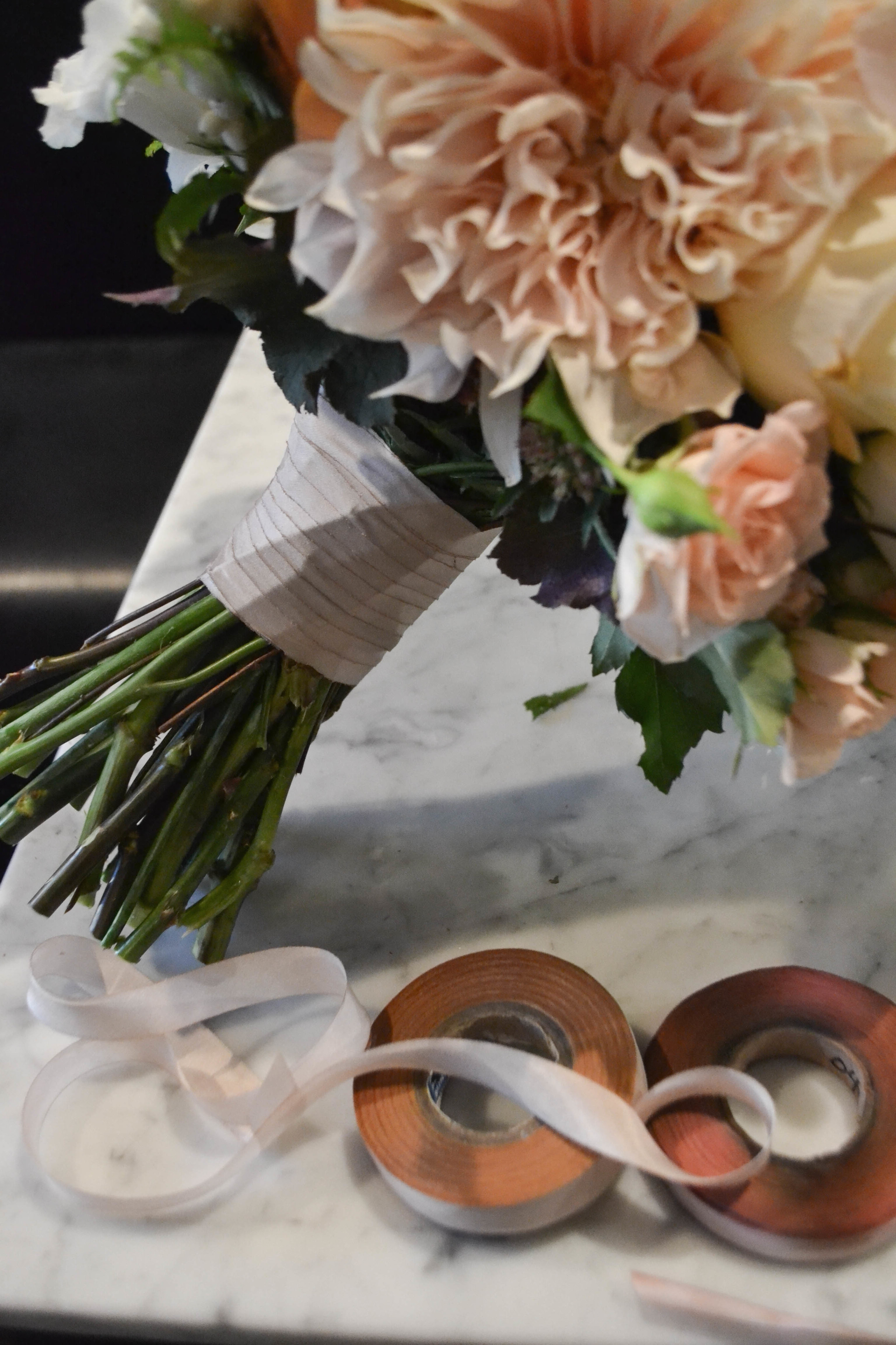 Bridal bouquet including cafe au lait dahlias, garden roses, sahara rose, spray rose and ranunculus. Lush round classic bouquet with faded fall colors. Gramercy Park Hotel Terrace Wedding. Rosehip Social Floral Design. 