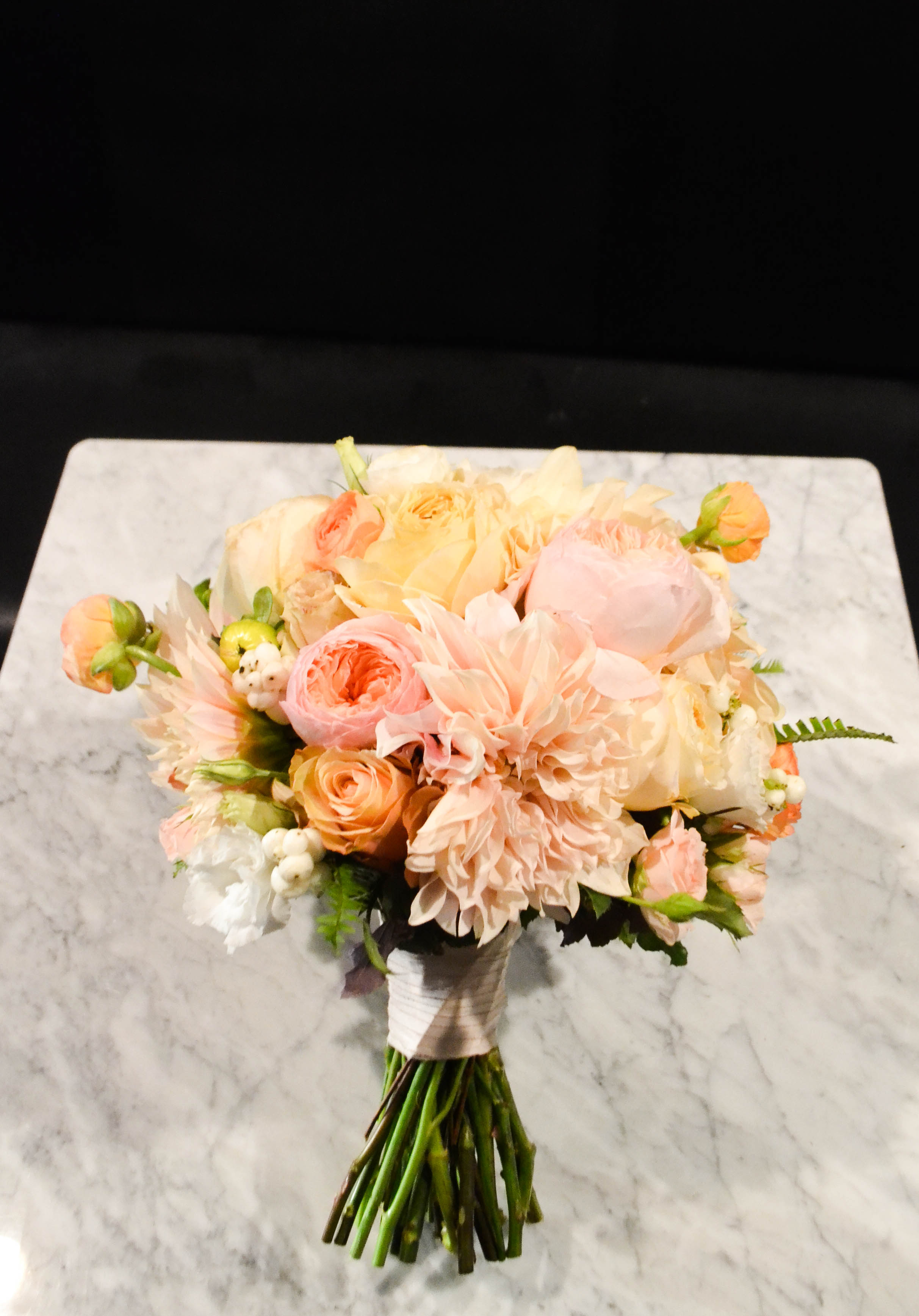 Bridal bouquet including cafe au lait dahlias, garden roses, sahara rose, spray rose and ranunkulous. Lush round classic bouquet with faded fall colors. Gramercy Park Hotel Terrace Wedding. Rosehip Social Floral Design. 