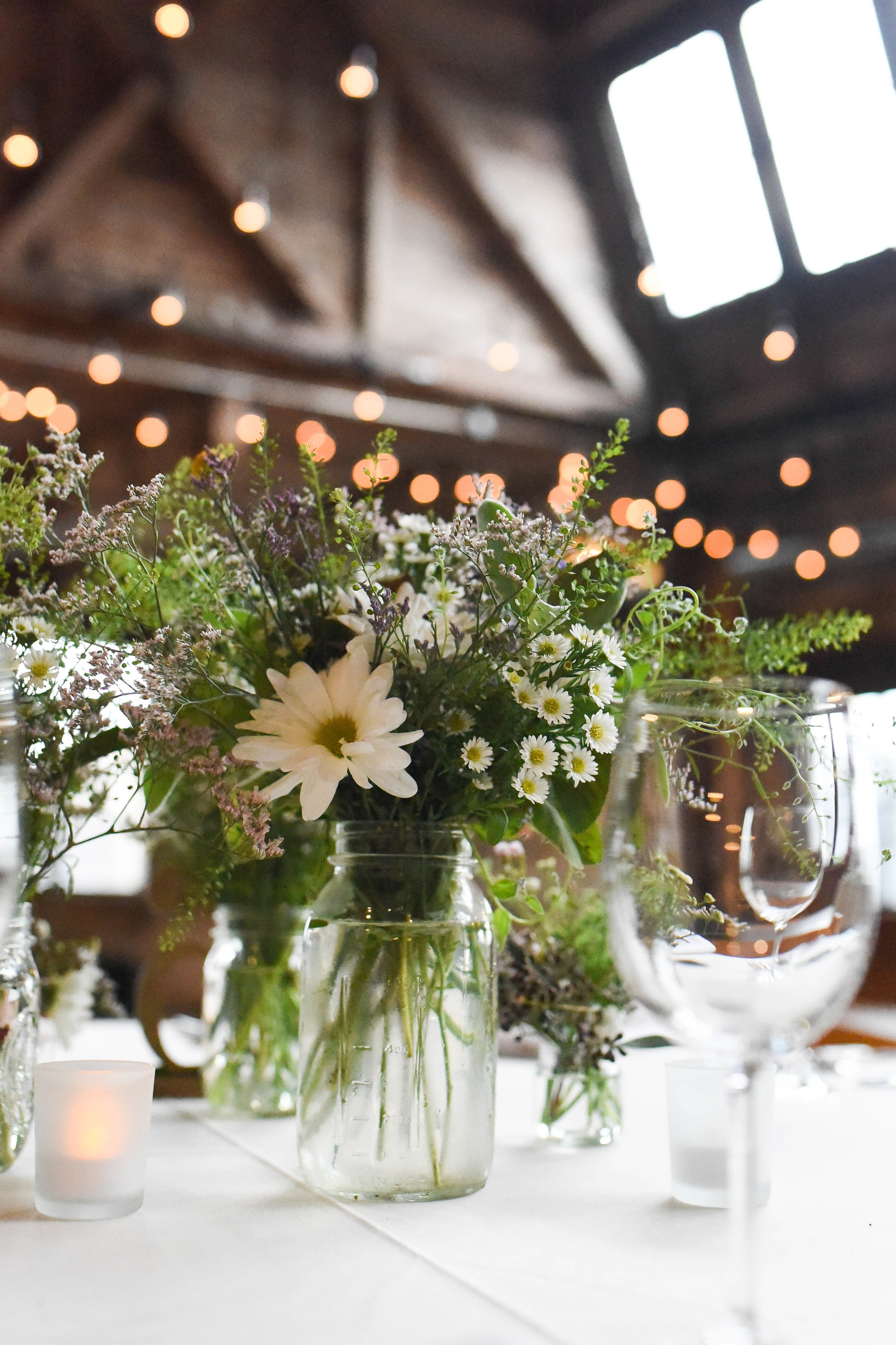 Yellow and lavender Wildflower centerpiece in rustic mason jar. Pale yellow, lavender, blush pink and orange flowers. Underrated and beautiful flowers. Greenpoint Loft wedding, Brooklyn. Flowers by Rosehip Social, Graham Ave, Brooklyn.