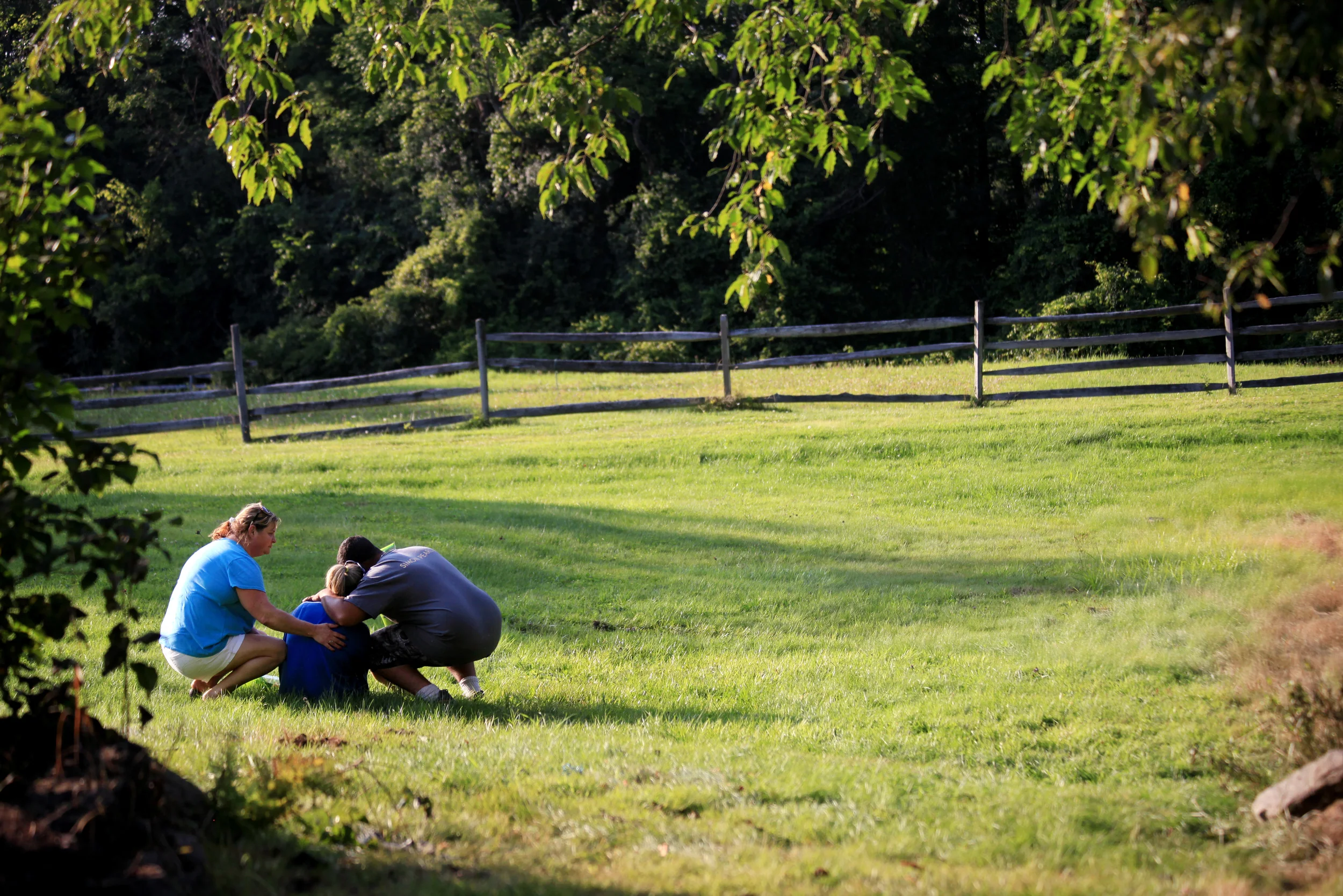 Family and friends comfort the mother of Jonathan Varnum at the scene of the car crash that killed him and two others on West Unity Road in Unity, N.H. on August 10, 2014. 