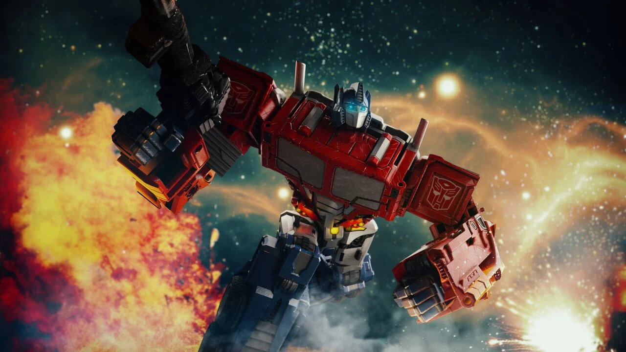 A large red and blue robotic figure, resembling Optimus Prime from Transformers, floating in space with explosions and stars in the background.