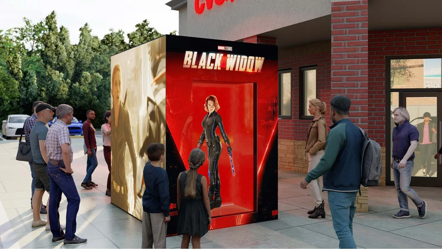 People standing in line and gathering around a Marvel Studios Black Widow display with a life-sized figure of Black Widow in her black suit, outside a building with a red brick wall.