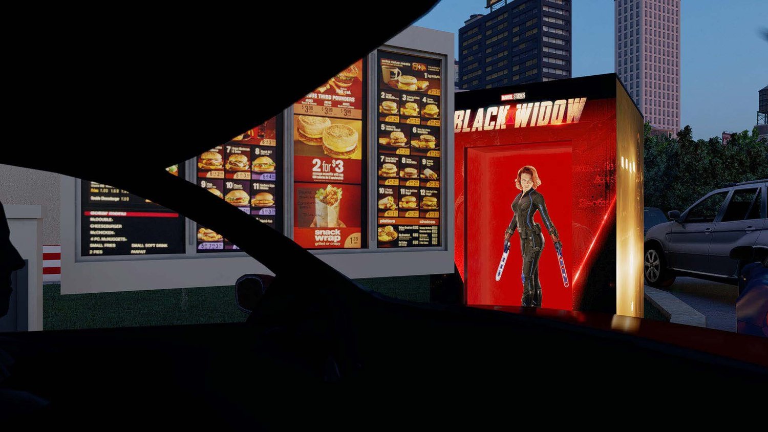 Inside a car at a drive-thru restaurant during evening, with digital menu boards displaying food items and prices, a person standing in front of a red and black vending machine themed after the Marvel movie 'Black Widow', and other cars parked nearby