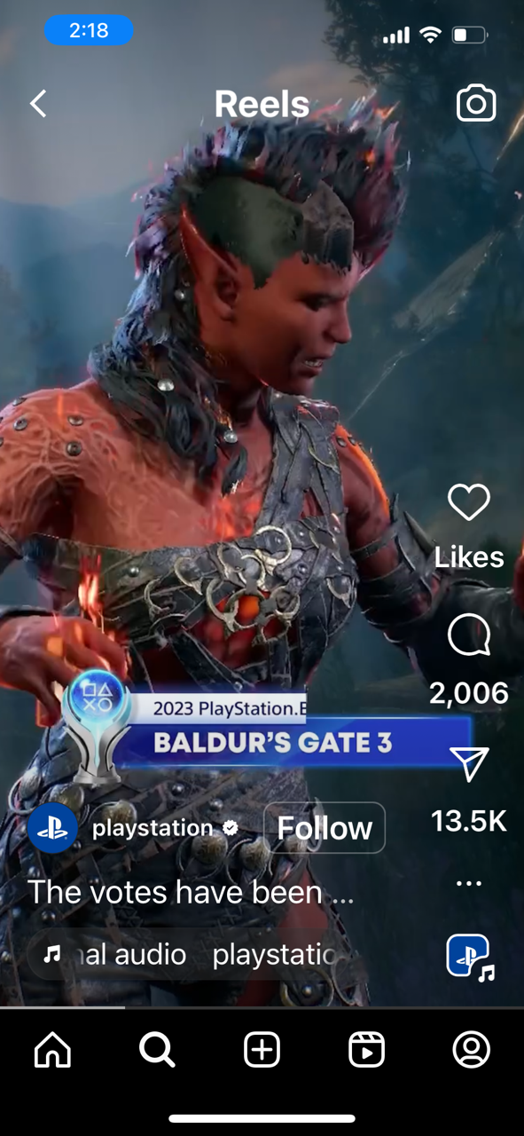 A person dressed as a fantasy warrior, with pointed elf-like ears, elaborate armor with metal and leather elements, and painted skin, looking down with a serious expression.