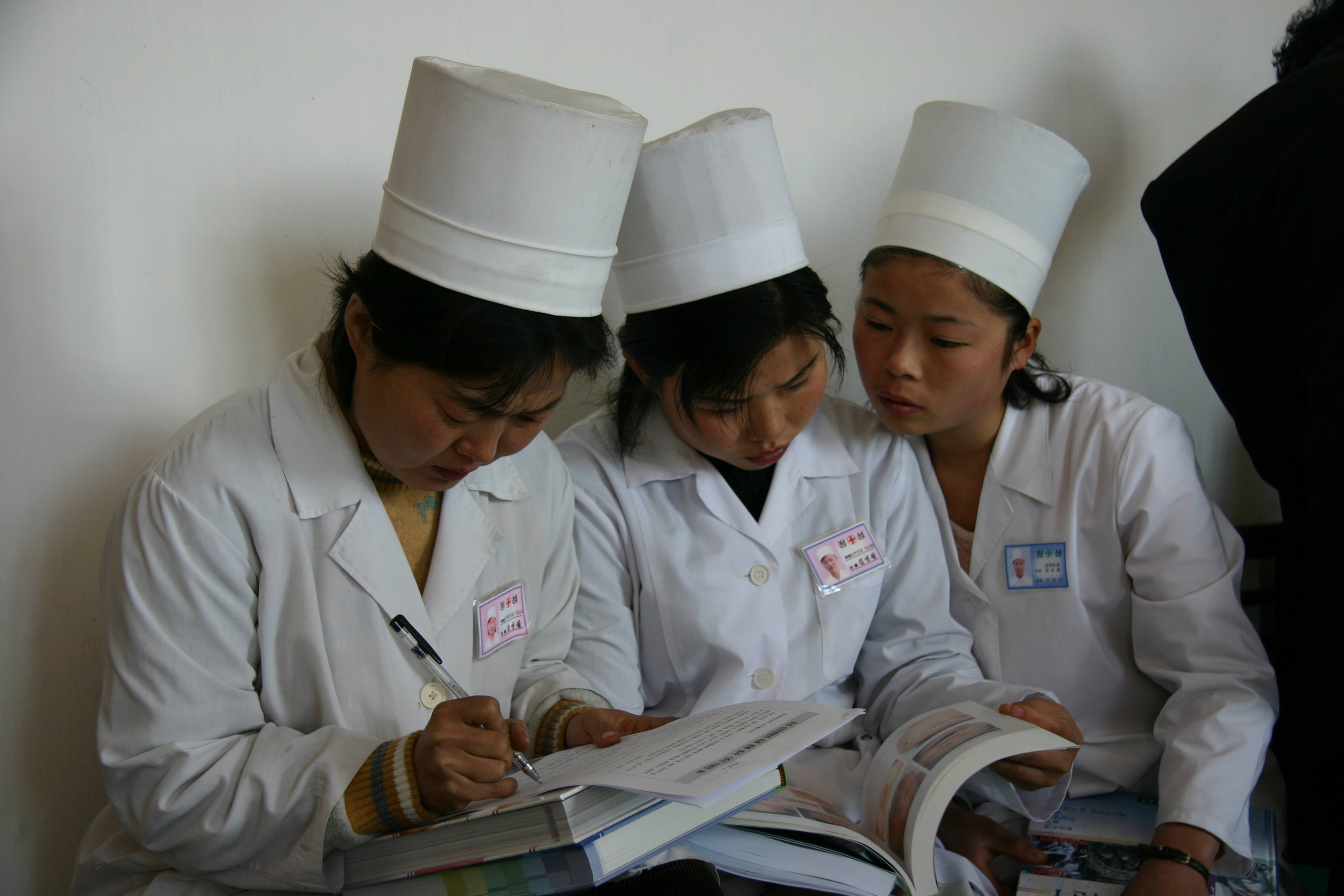 Physicians pouring over textbooks distributed by The Eugene Bell Foundation