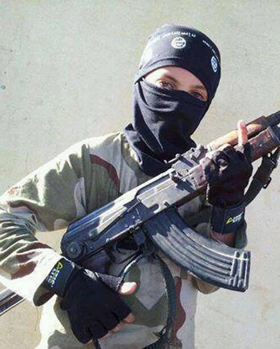 Raqqa Is Being Slaughtered Silently, an anti-Islamic State organization, distributed this photo a child wearing a hat with the Islamic State logo posing with a weapon in Raqqa, Syria. Across the vast region in Syria and Iraq that is part of the Islamic State group’s self-declared caliphate, children are being inculcated with the extremist group’s radical and violent interpretation of Shariah law. | Raqqa Is Being Slaughtered Silently