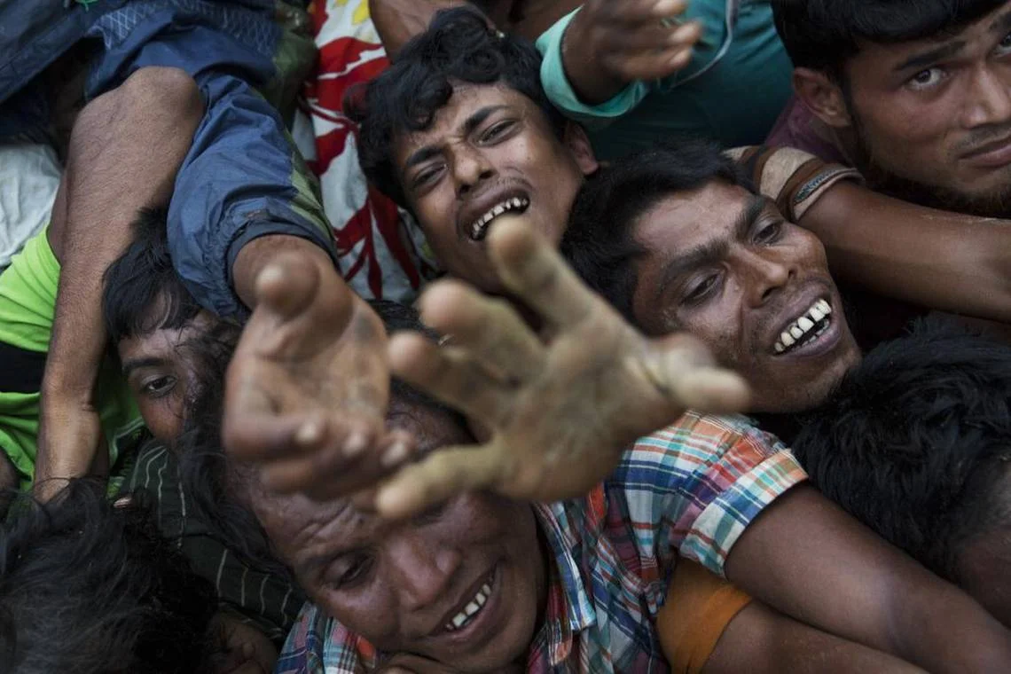 Rohingya Muslims stretch out their arms to reach food being distributed near Balukhali refugee camp in Cox's Bazar, Bangladesh, Wednesday, Sept. 20, 2017. With Rohingya refugees still flooding across the border from Myanmar, those packed into camps and makeshift settlements in Bangladesh are desperate for scant basic resources and fights erupt over food and water. Bernat Armangue AP
