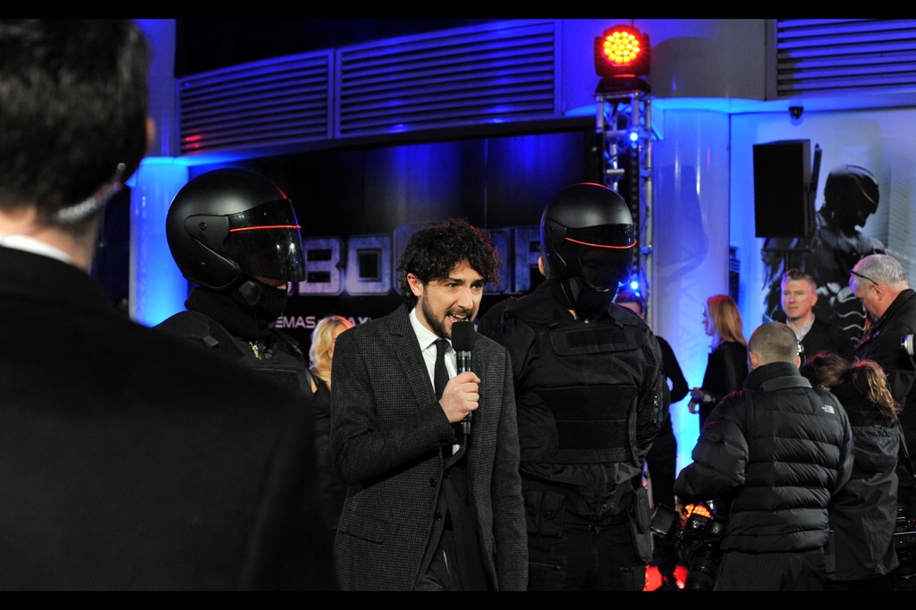 "Hi, I'm Alex Zane and I'd like to welcome you to this premiere on behalf of the benevolent police state representatives who even now have kidnapped my family and are holding a gun to my head. On a related note, this movie is amazing and you should all go watch it"