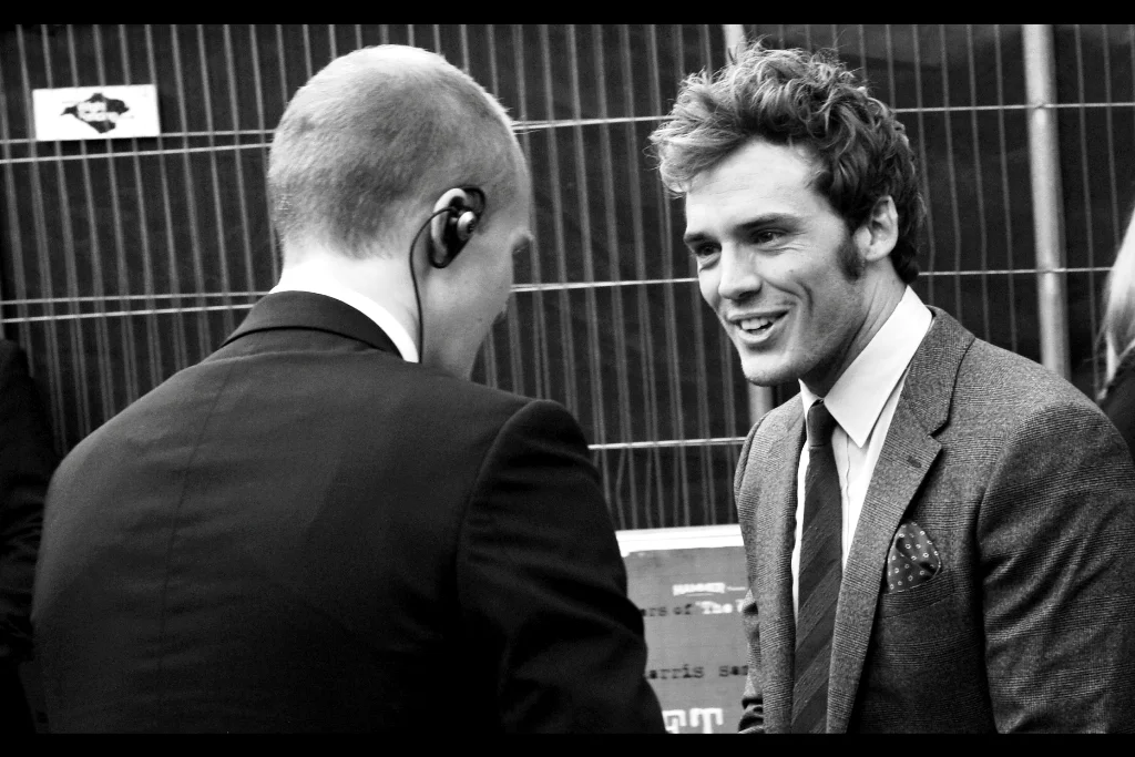 "Be honest, that's Justin Bieber coming from your earpiece, isn't it?" Sam Claflin has arrived, and he's just taken the moral highground away from the security staff.