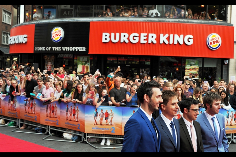 Excellently, the four arrange themselves in front of the VIP Paparazzi cordon in front of a duly designated Fast Food Restaurant Product Placement as the crowd screams their approval, calls for their autographs, and feel faint or dizzy or get the vapours or whatever teen girls do when they get in proximity to famous teenage guys.