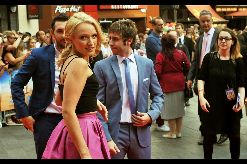 Emily Berrington is wearing a dress profoundly purple enough to draw the attention of (for now) two of our heroes. The other two are hastening for another photo opportunity, to the no-doubt chagrin of all the girls in the crowd.