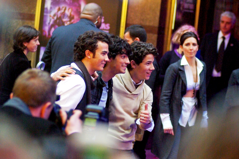 All smiles. They know that instead of the exhaustion of having to actually play a world tour, they've filmed one concert once and can now travel the world and promote it (Disney executives : give yourself another round of high-fives!)