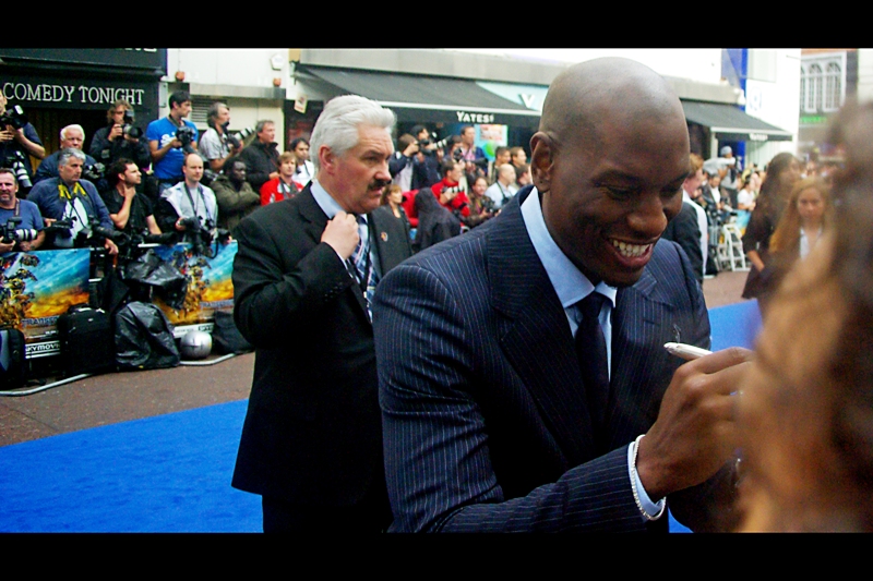 The Red (Blue) Carpet is far too packed to take photos of people getting out of cars or posing for the Paparazzi, and they haven''t yet begun to be interviewed where they'll be blocked by passersby and hovering attendants in orbit around them. Still... for now, this is Actor Tyrese Gibson (and behind him, the head of security at most of these premieres. Hmm.... perhaps I should pixelate him out of the picture to protect his identity?)