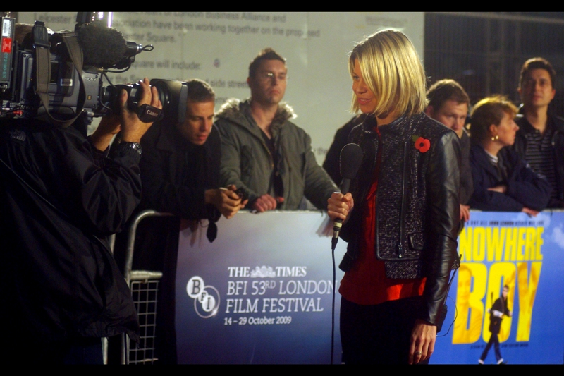 "Tom, I'm here at the premiere for 'Nowhere Boy'. Yellow Cap Guy is not here, and the Pentax K10D belonging to that guy over there is already looking forward to a quieter couple of weeks once tonight is over"