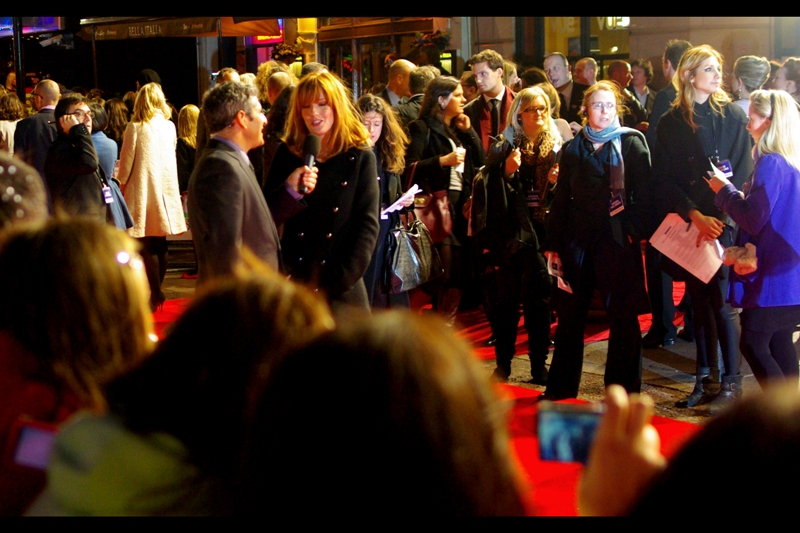 Actress Kelly Reilly being interviewed (left of frame). My position in the crowd was not ideal, and I could theoretically have gotten a better vantagepoint at time of arrival. However I stayed where I was because I figured it held the best chance of getting celeb shots when they were standing relatively still ... also, it allowed me to photograph girls in blue/purple jackets.