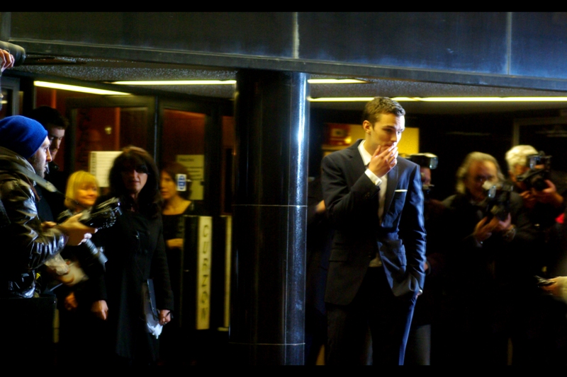 Nicholas Hoult impresses the assembled fans’n’paps by stopping to smoke a cigarette that he’s *not actually holding*. And that? *That’s* acting, baby.