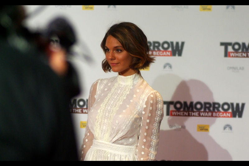 Caitlin Stasey plays the lead character in this film. She looks great holding a machine gun (though admittedly not wearing this particular dress)