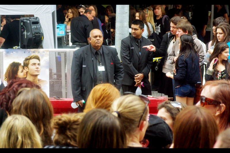I return, and find that things are starting To Get Real. As in... a security guard with a water sprayer? That's... not a lot of deterrent given the kind of crazed fan I'm already seeing.