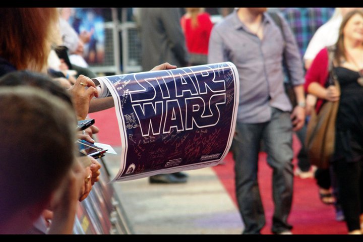 My first comment upon seeing this poster was "No effing way". Partly as in "that is SOOOOO COOL", but also as in, No effing way does somebody have that many signatures on a Star Wars poster and bring it to a London premiere where it might rain and get crushed. Not without a security detail and a handgun and a perspex tent to stand in. (Then again, yellow cap guy has been known to bring newspapers for people to sign...)