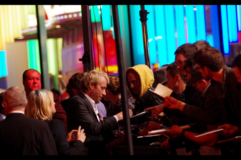 Actor Rhys Ifans signs for Awesomely Creepy Yellow Hooded Guy (no relation to the guy who used to wear the cap of the same colour). Meanwhile the colour of Tomato Red Security Guard Dude is provided courtesy of the fantastic lighting of the Leicester Square M&Ms Store