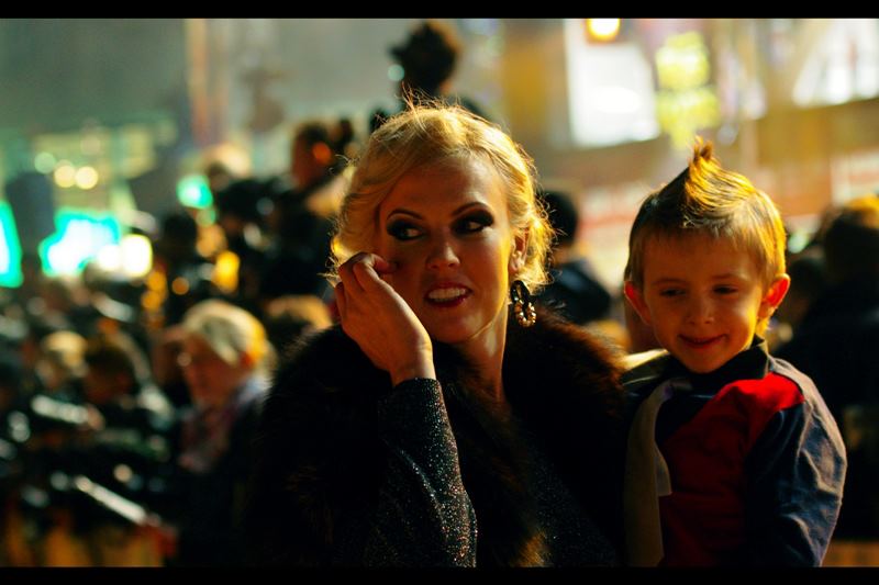 No idea who she is, but the Paparazzi were distracted by her, and/or her son's amazing hairstyle.