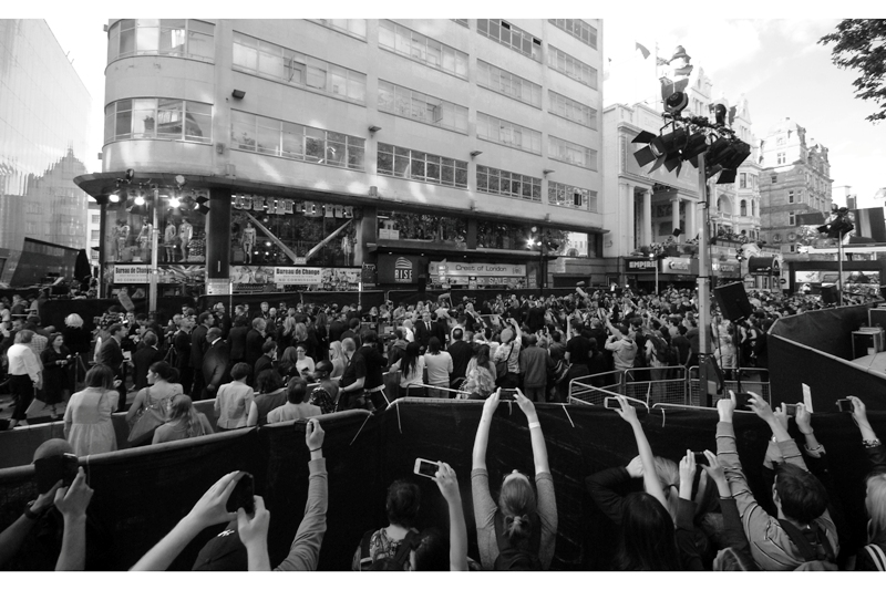 The monopod means that my camera is at an elevation probably about 3meters plus, and it's getting admiring stares from people restricted to mobile phones held high. Sadly, I'm using a 10mm wide angle lens, and even at maximum megapixels and resolution, Brad Pitt is going to be a few pixels tall if I even get a shot. (Still-- I'm taking photos of others' desperation. That's always fun).
