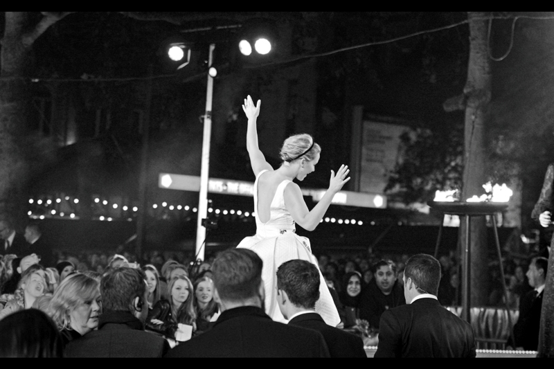 My life improves meaningfully as Jennifer Lawrence dances onto the stage. But will she buck the horrific trend of people on stage not turning around to acknowledge the only unacknowledged public pen at this premiere?