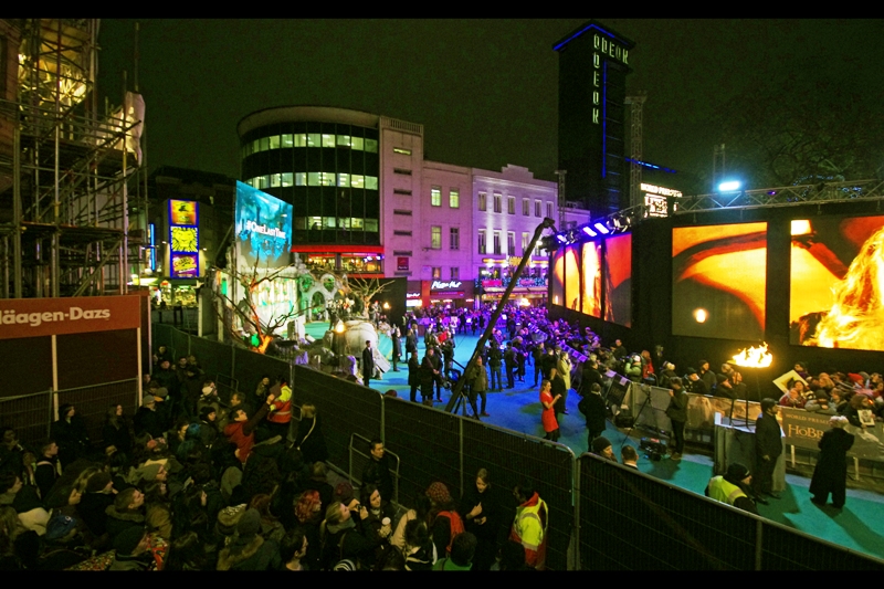 A few hours pass and it's now dark, and the crowd where I am has grown considerably. The ones hiding inside the 'nest of umbrellas' stored in a large box that's over 50cm high next to 'Muriel's Kitchen' will be lucky if they're not told to get out. My position is safer than theirs. I'm standing on pavement. Upon which I have placed a step-stool.
