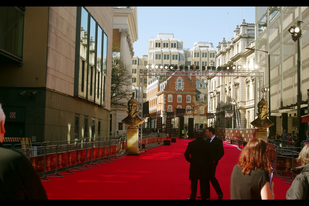 It’s a Redcarpet, and my wrist number 124 afforded me a front-row spot just behind the first of the black cubes you can see on the carpet on the left hand side. Not exactly pole position, but it jutted out slightly, geographically. And at least in picking a spot like that, my theatre credentials weren’t writing cheques that a cursory glance at the junk in my DVD collection could never cash.