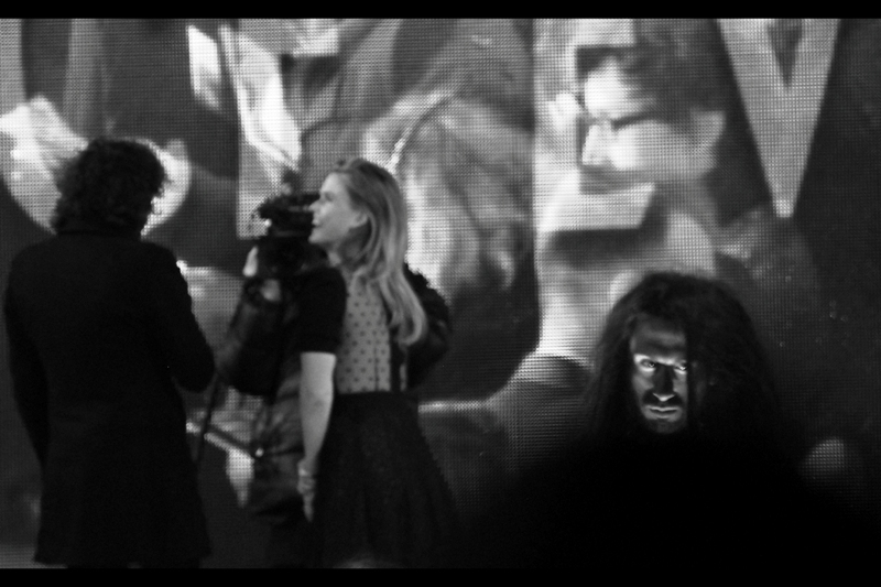 Creepy Caveman Guy on Plinth is creepy while Alice Eve is interviewed on stage.