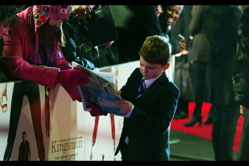 "Six Across? 'DIRIGIBLE', ma'am. Is this your first crossword?" Wireimage identifies the kid as "Alex Nikolov", who plays 'Young Eggsy' in the film. And I'm not nearly tired enough to fail to consider that odd.