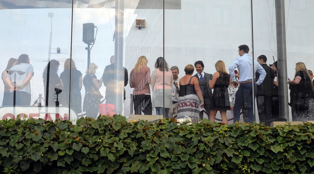 Unsurprisingly, Tom Cruise has shown up half an hour before the scheduled arrivals - but surprisingly he's starting INDOORS on the inner upper floor, mingling with VIP fans.