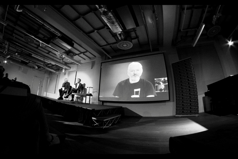 Julian Assange joins us, and his t-shirt contains a graphic of an empty chair. (The book he's publishing is more direct and less metaphorical).