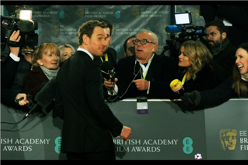 "Hey, buddy... I'm especially wearing Apple headphones for this interiews - stop looking at the screaming fans over there!" - Michael Fassbender was nominated for a Bafta for Best Supporting Actor for Steve Jobs.